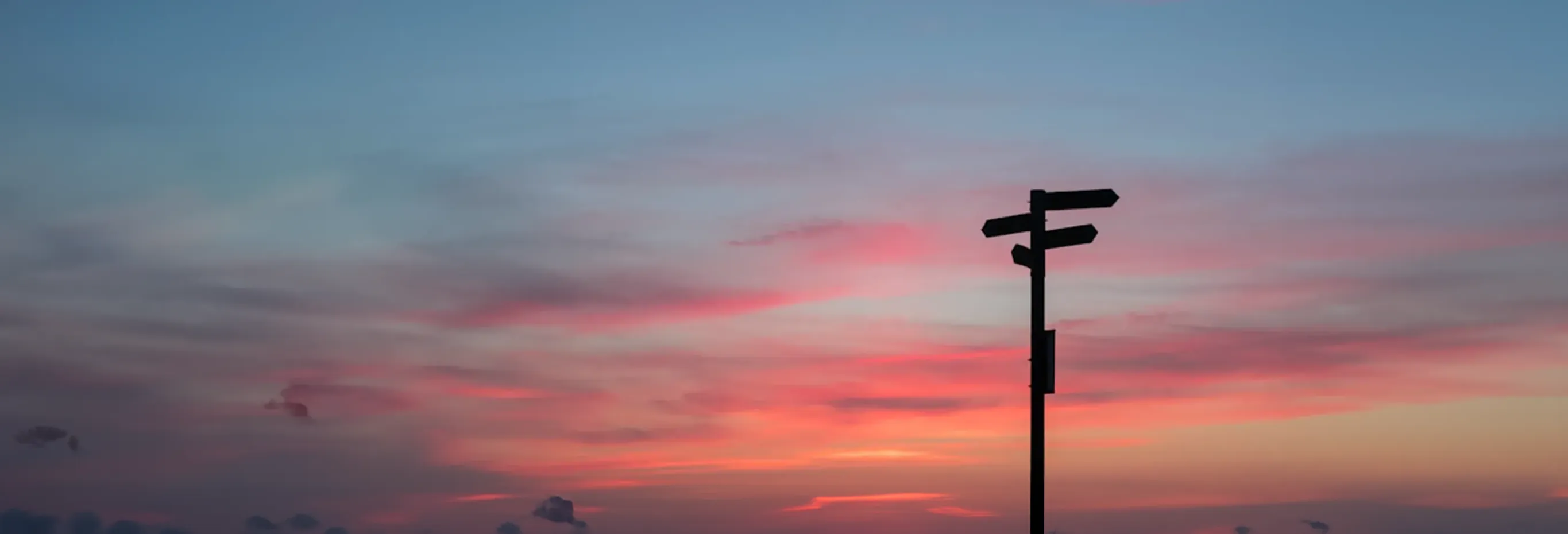 Pink sky and direction sign boards